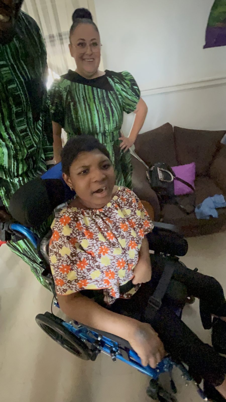 Petra in her wheelchair with a volunteer by her side.